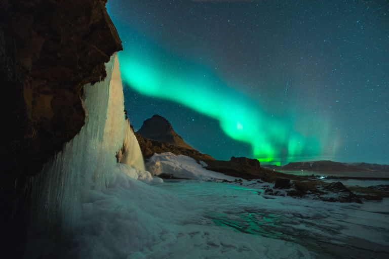 Image showing the green tinge of the northern lights behind an icy landscape.